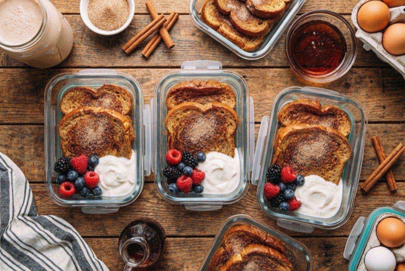 Golden cinnamon French toast slices topped with fresh strawberries and maple syrup on a plate