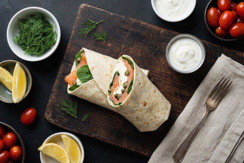 Sliced wrap showing layers of smoked salmon, fluffy egg whites, avocado, and fresh dill