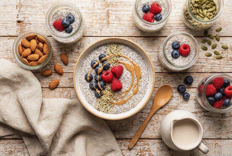 Creamy chia seed pudding in a glass jar topped with raspberries and a drizzle of almond butter