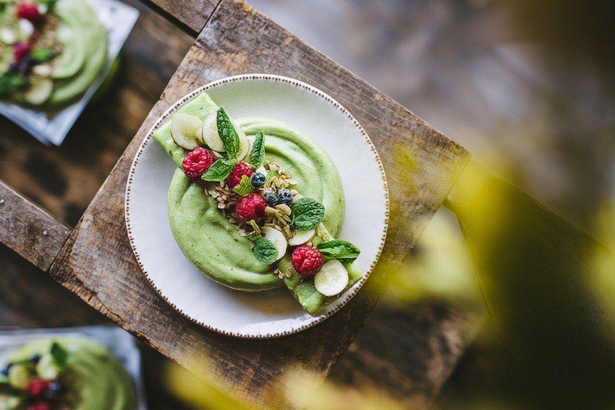 Seven labeled freezer bags filled with green spinach, banana slices, and mango chunks laid flat on a countertop